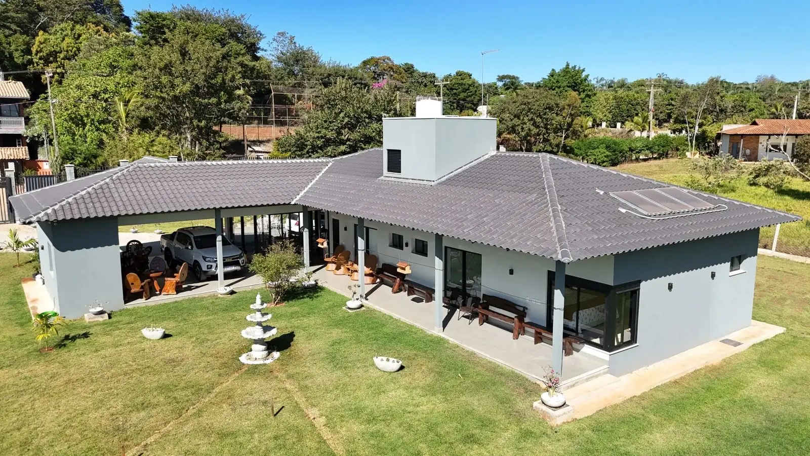 Casa H&R em Hidrolândia: residência térrea de alto padrão com telhado americano e fachada de pedra, vista de drone